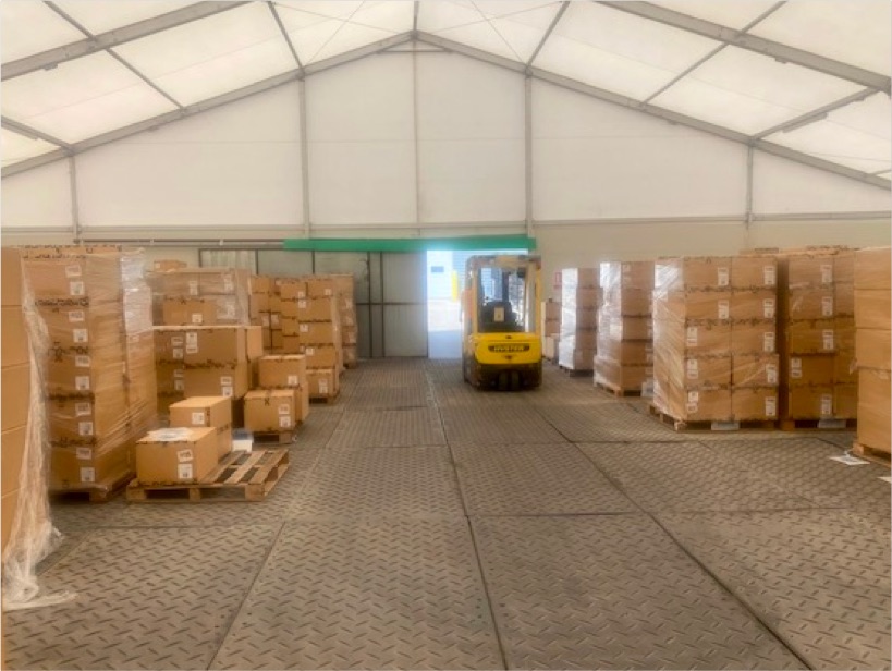 The inside of a large temporary warehouse that's used for storage.